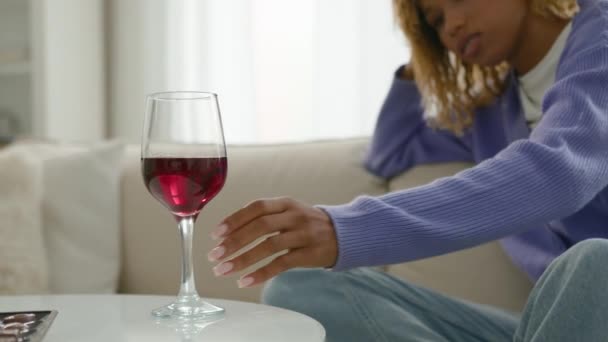 アフリカ系アメリカ人女性アルコール中毒女性一人でリラックスして考える問題はワイングラスを見て思慮深い赤ワインの飲み物のガラスを取る - 映像、動画