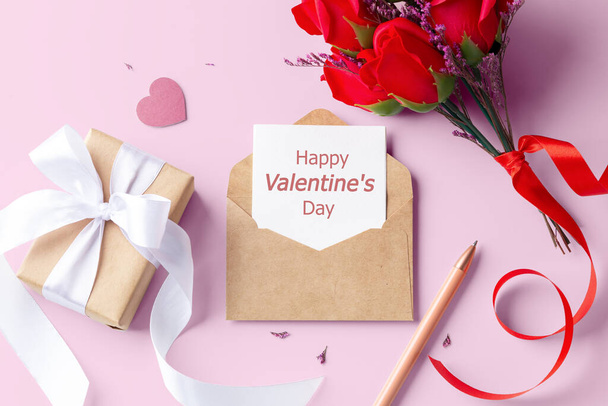Valentine kortti kraft kirjekuoressa lahjapaketti ja nousi vaaleanpunainen tausta, ylhäältä - Valokuva, kuva