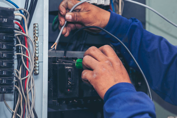 Electrical mechanic technician check wire electric cabinet. Inspector men hands working switchboard machinery maintenance service. Electrician circuit repair voltage operation. Men hands fix breaker - Photo, Image