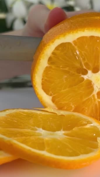 Mujer rebanando naranja en la cocina de cerca. Joven asiática ama de casa rebanando naranja cruda para prepararse para la comida y la cena. Concepto de cocina casera. Imágenes de alta calidad 4k - Metraje, vídeo