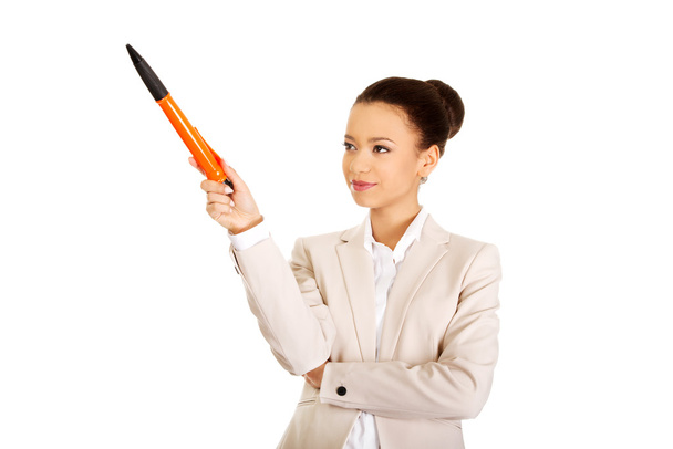 Businesswoman pointing up with big pen. - Foto, Imagen