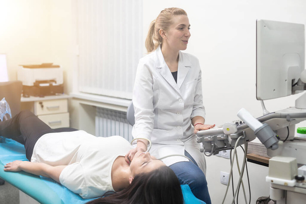 Kadın endokrinolog ultrason ofisinde kadın bir hastaya ultrasonografi yapıyor. Ultrason tanıları. - Fotoğraf, Görsel