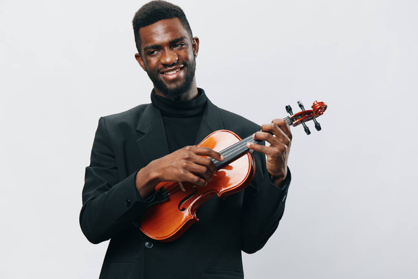 Appassionato giovane afroamericano in mostra il suo talento suonando il violino, isolato su sfondo bianco - Foto, immagini