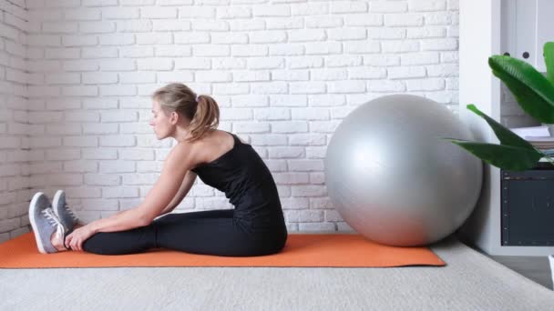 young fit woman working out at home with stability ball or fitness ball - Footage, Video