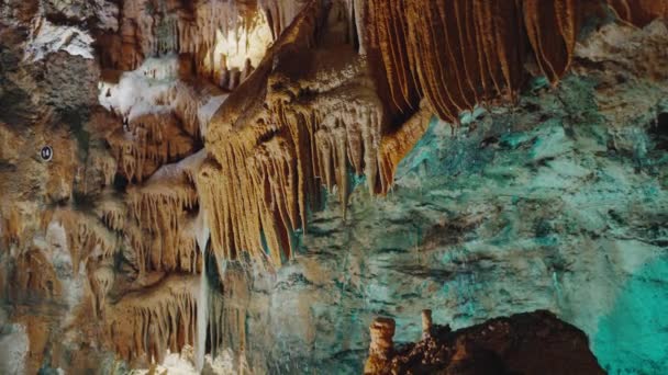 Esplora una grotta sotterranea ornata da un'abbondanza di formazioni di stalattiti appese al soffitto. - Filmati, video