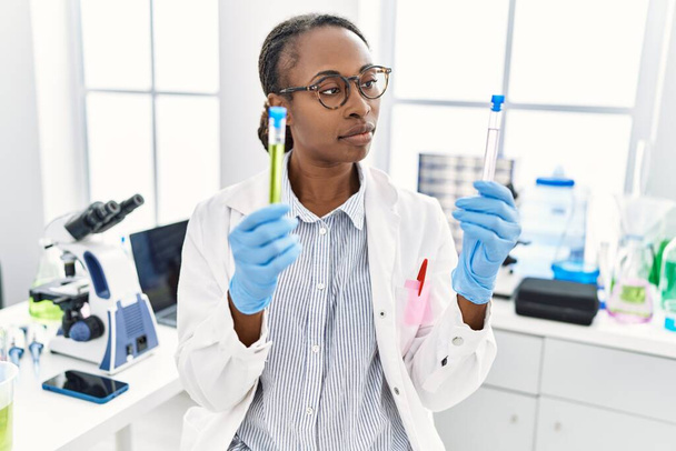 Afrikanische Wissenschaftlerin hält Reagenzgläser im Labor - Foto, Bild