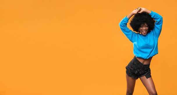 Fröhliche Afroamerikanerin im blauen Sweatshirt. - Foto, Bild