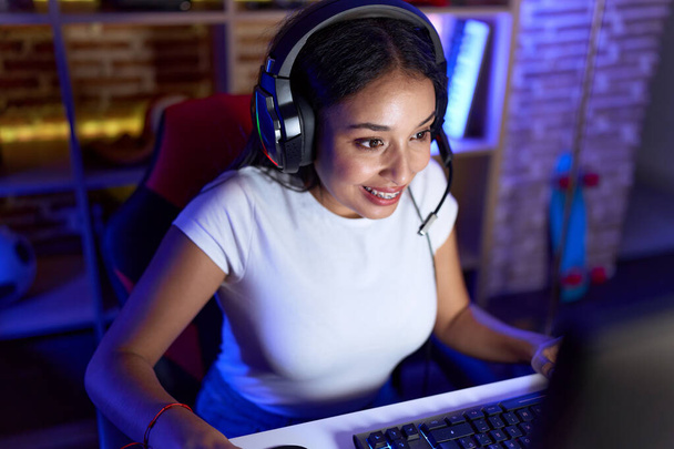 Jovem árabe mulher streamer jogar jogo de vídeo usando computador na sala de jogos - Foto, Imagem