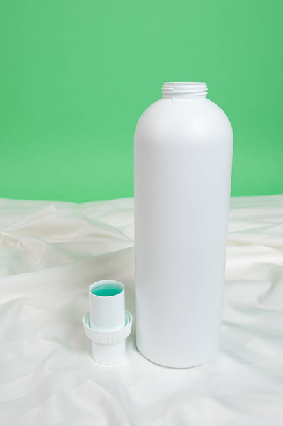 Détergent à lessive liquide naturel sur fond de tissu satiné blanc - Photo, image