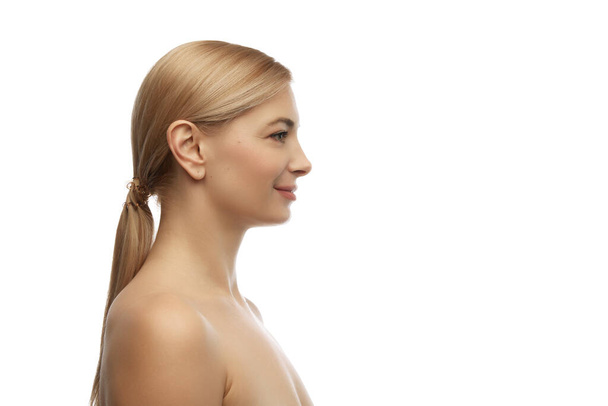 Side view portrait of young, beautiful, tender woman smiling looking away against white studio background. Concept of natural beauty, anti aging, cosmetology, plastic surgery, spa treatments. Ad - Photo, Image