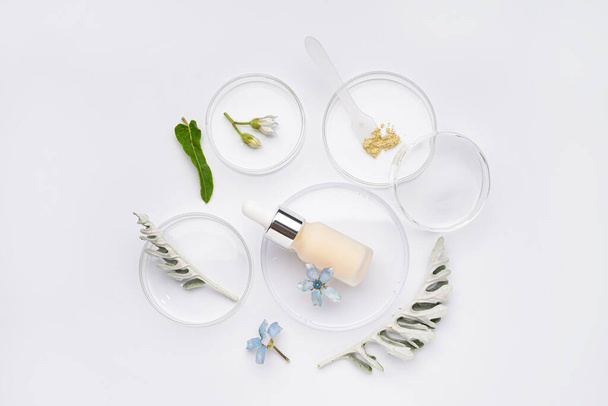 Πιάτα Petri με δείγμα, βότανα και μπουκάλι καλλυντικού προϊόντος σε λευκό φόντο - Φωτογραφία, εικόνα
