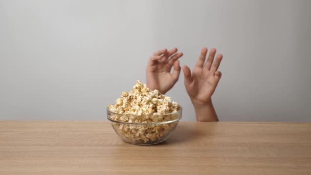 A gyerekek kezei az asztal alól láthatók, amint popcornt próbálnak leszedni az asztalról.. - Felvétel, videó