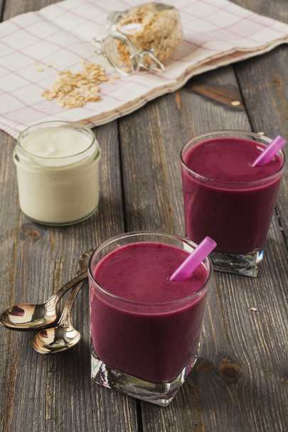 Smoothie made with frozen red berries,milk, and oatmeal in a glasses in wooden background.Selective focus. - Foto, Bild