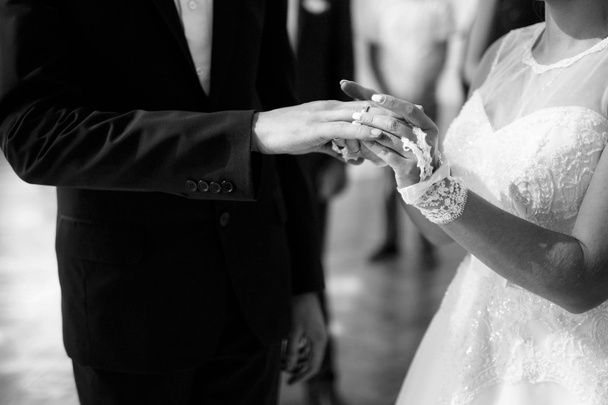 Vrouw zetten een ring vinger van zijn mooie bruidegom. - Foto, afbeelding