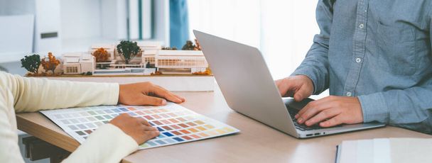 Építész belsőépítész kiválasztja szín segítségével színminták során kollégája keres információt segítségével laptop. Kreatív tervezés és csapatmunka koncepció. Közelkép. Változatos. - Fotó, kép