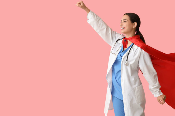 Belle femme médecin en costume de super-héros sur fond rose - Photo, image