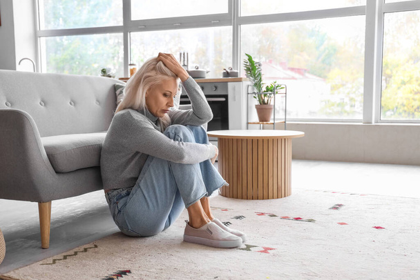Depresja Dojrzałe kobieta siedzi na podłodze w domu - Zdjęcie, obraz