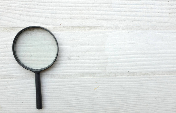 top view and close up magnifying glass loupe search symbol isolate on the wooden table white backdrop.Searching information data on internet ,Minimal creative concept.  - Photo, Image