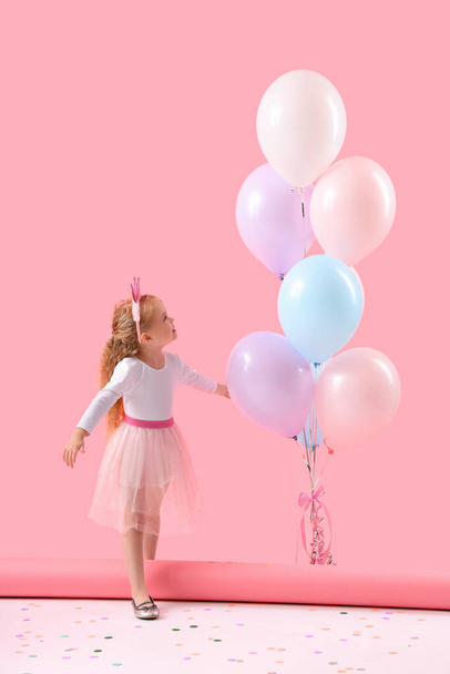 Aranyos kislány gyönyörű lufik rózsaszín háttér - Fotó, kép