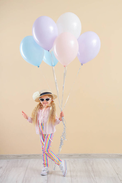 Söpö pieni tyttö kauniita ilmapalloja lähellä beige seinä - Valokuva, kuva
