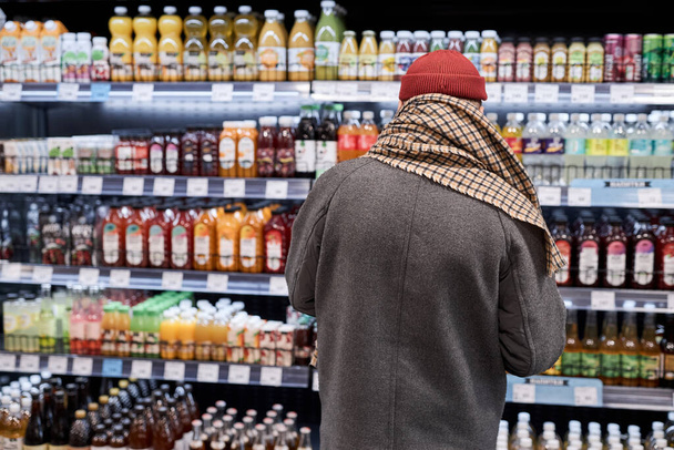 Widok wsteczny nierozpoznawalnego staruszka robiącego zakupy w supermarkecie i kupującego artykuły spożywcze, przestrzeń do kopiowania - Zdjęcie, obraz