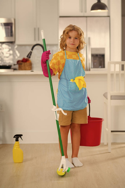 Cleaning at home. Little kid cleaning at home. Child doing housework having fun. Portrait of child housekeeper with wet flat mop on kitchen interior background - Zdjęcie, obraz
