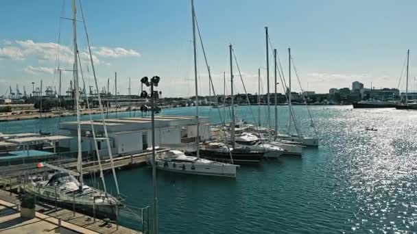 Marina w Walencji z tłem przemysłowym, port Walencja żyje żaglówki i odległe dźwigi przemysłowe - Materiał filmowy, wideo