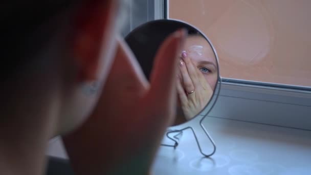 Jonge mooie vrouw brengt een masker aan op problematische delen van het gezicht. Problemen met acne breakouts op het gezicht van tieners. Gezichtsverzorging. Professionele huidverzorgingsproducten. - Video