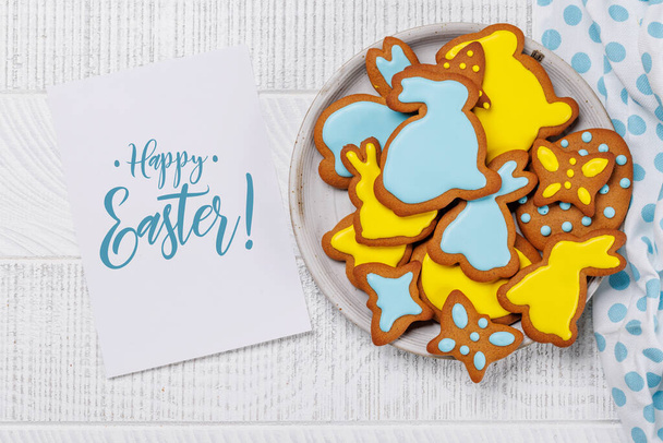 イースターの甘さ:お祝いの形をした好ましいジンジャーブレッドクッキー. コピースペースカードと平らな層 - 写真・画像