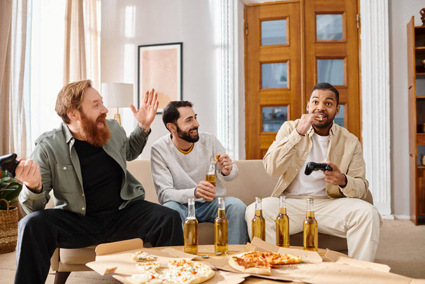 Drei gutaussehende, fröhliche Männer verschiedener Rassen teilen sich an einem Tisch Pizza und Bier und genießen einen ungezwungenen Abend der Freundschaft. - Foto, Bild