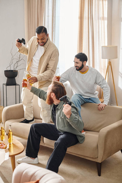 Tres hombres alegres y guapos de diferentes razas disfrutan de tiempo de calidad juntos en una acogedora sala de estar. - Foto, Imagen