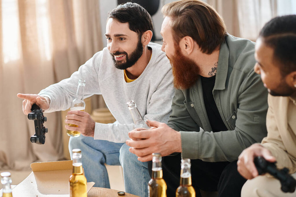 Trzech wesołych, międzyrasowych mężczyzn cieszy się swobodnym spotkaniem, śmiejąc się i rozmawiając przy butelkach piwa na stole. - Zdjęcie, obraz