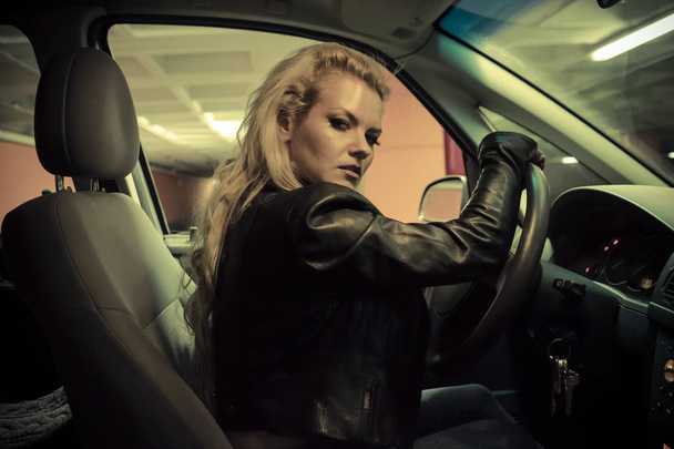 Blonde in car driving at night - Фото, изображение