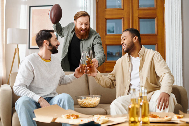 Drei fröhliche, interrassische Männer in lässiger Kleidung sitzen auf einer Couch, verbinden sich und genießen die Gesellschaft der anderen. - Foto, Bild