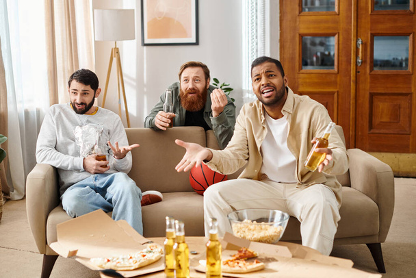 Tres hombres guapos y alegres de diferentes razas en un lazo casual y relajarse en un sofá, encarnando la esencia de la amistad. - Foto, imagen