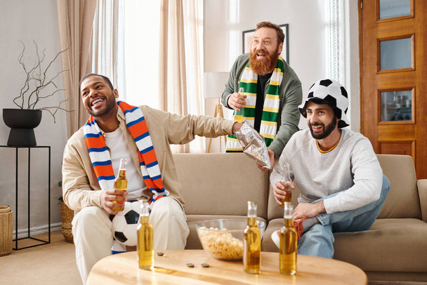 Kolme tyylikästä miestä, eri etniset ryhmät, istuvat onnellisina sohvalla, rakentaen sydäntä lämmittävää ystävyyttä.. - Valokuva, kuva