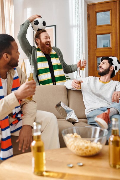 Drei gutaussehende, fröhliche Männer unterschiedlicher Rassen verbringen einen unbeschwerten Moment gemeinsam auf einer Couch zu Hause. - Foto, Bild