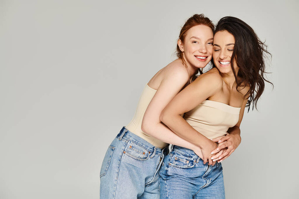 Deux jeunes femmes en tenue élégante s'embrassant joyeusement tout en posant pour une photo. - Photo, image