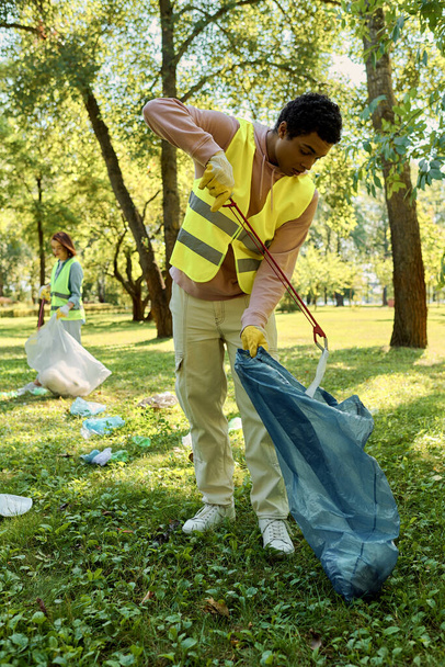 Hombre afroamericano con camisa amarilla sostiene una bolsa azul sobre un fondo vibrante con su esposa. - Foto, imagen