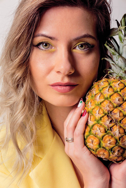 hermosa mujer rubia con maquillaje amarillo y maquillaje creativo de piña  - Foto, imagen