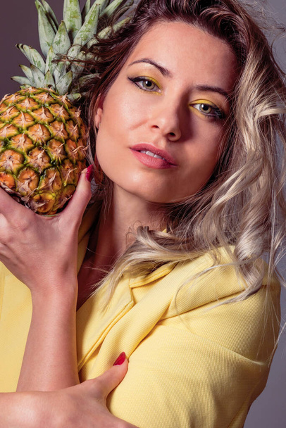hermosa mujer rubia con maquillaje amarillo y maquillaje creativo de piña  - Foto, Imagen