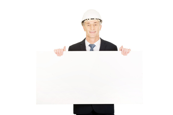 Businessman with hard hat holding empty banner - Φωτογραφία, εικόνα