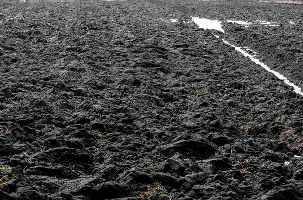Keväällä kynittyä mustaa peltoa. Maaperän valmistelu pellolla viljelykasvien kylvämistä varten - Valokuva, kuva