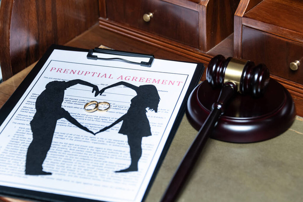 Обкладинка, що має дострокову угоду з вирізаним силуетом пари і обручок, поруч з суддями, наданими - Фото, зображення
