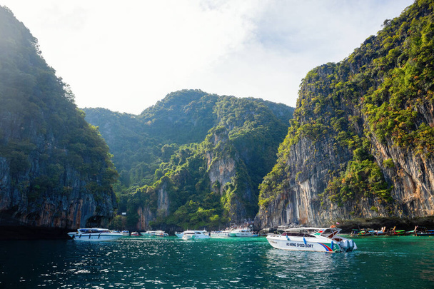 Phi Phi, Tailândia - 23 de novembro de 2023: Barcos de cruzeiro e iates perto das ilhas Phi Phi - um dos lugares mais famosos com vistas para o paraíso e rochas verdes  - Foto, Imagem