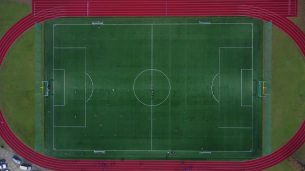 Vista aérea de los niños jugando al fútbol en el campo verde. Vista superior de los jugadores de fútbol en el estadio pequeño. Los niños juegan al fútbol - Metraje, vídeo