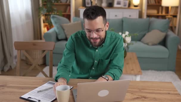 uomo adulto caucasico con barba e occhiali lavoro sul computer portatile a casa  - Filmati, video