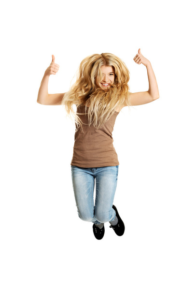 Young student jumping with thumbs up - Photo, image