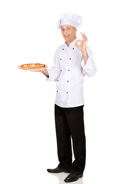 Chef baker with italian pizza showing perfect sign - Foto, afbeelding