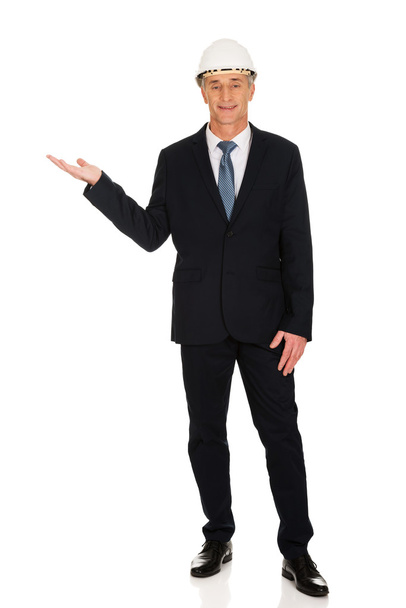 Businessman with hard hat holding copyspace - Фото, изображение